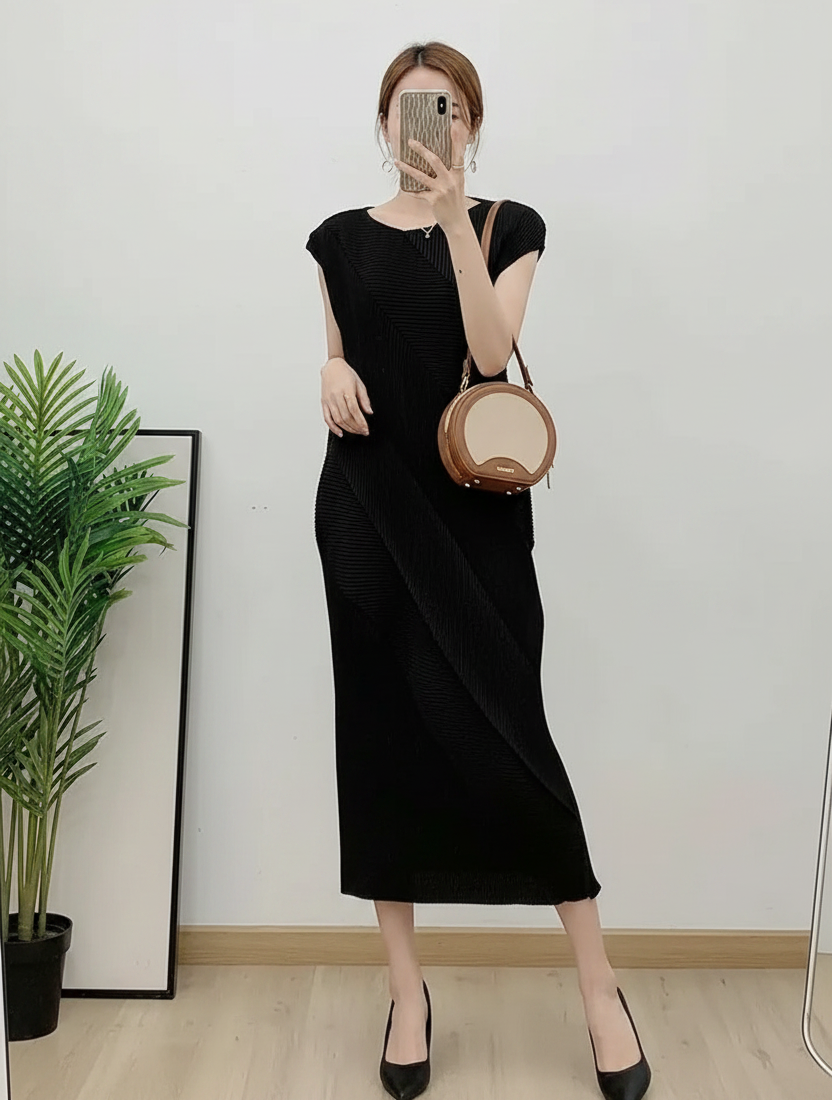 Person wearing a black dress holding a round brown bag indoors.