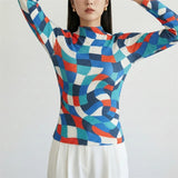 Person wearing a colorful geometric patterned sweater on a white background