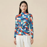 Woman wearing a colorful geometric-patterned sweater against a beige background