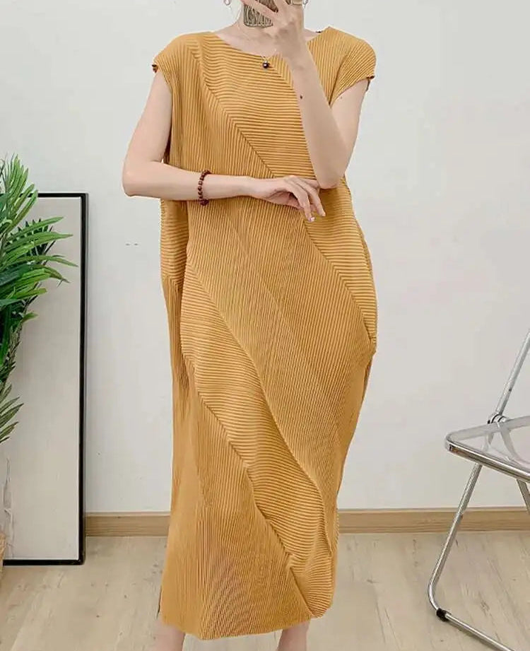 Person wearing a mustard yellow dress in a minimal indoor setting.