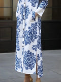 Long white dress with blue floral pattern worn by a person outdoors.