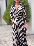 Woman wearing a black and white patterned dress outdoors.