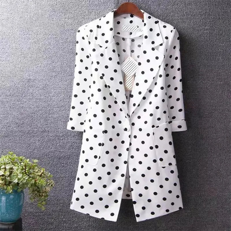 White blazer with black polka dots on a gray background