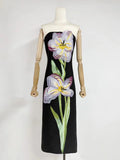 Black dress with floral design on a mannequin against a white background