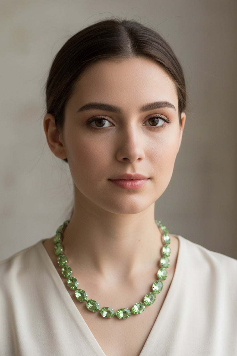 Green gemstone necklace on a mannequin bust against a brown background