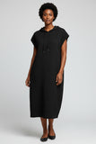 Black sleeveless dress on a hanger against a neutral background