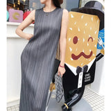 Woman in a gray dress standing next to a scooter with a cartoon cake design.