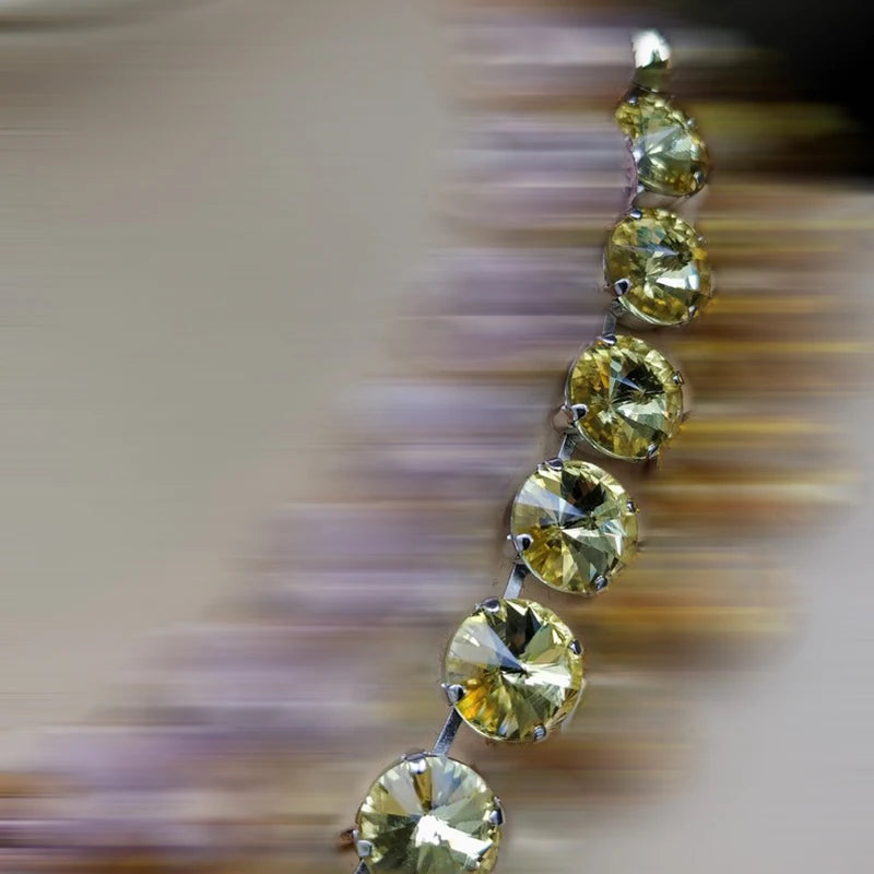Gold earring with clear stones on a blurred background