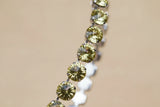 Gold earring with clear stones on a blurred background