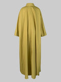 Long mustard yellow dress on a gray background