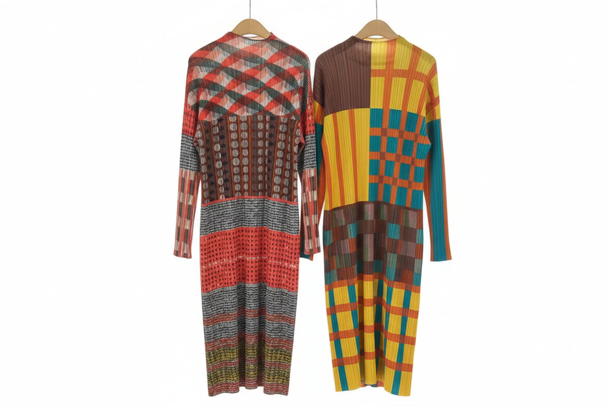 Two colorful patterned dresses hanging on a rack in a room.