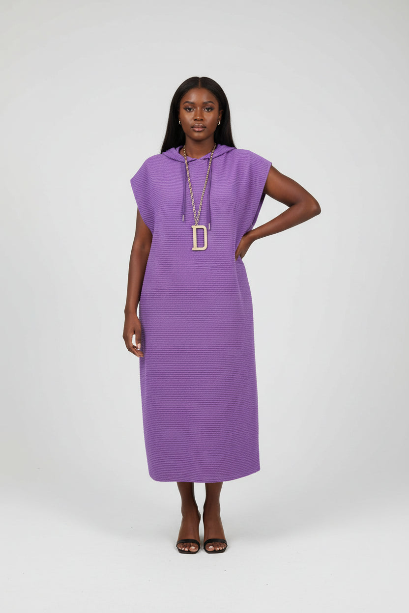 Purple sleeveless dress on a mannequin with a plant in the background