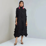 Woman wearing a black dress with textured pattern on a white background