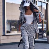 Person wearing a checkered outfit with a white cap in an urban setting