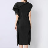 Woman wearing a black dress with a plain white background