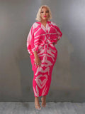 Woman wearing a pink and white patterned dress against a plain background