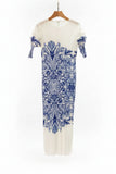 White dress with blue floral pattern on a hanger in a clothing store.