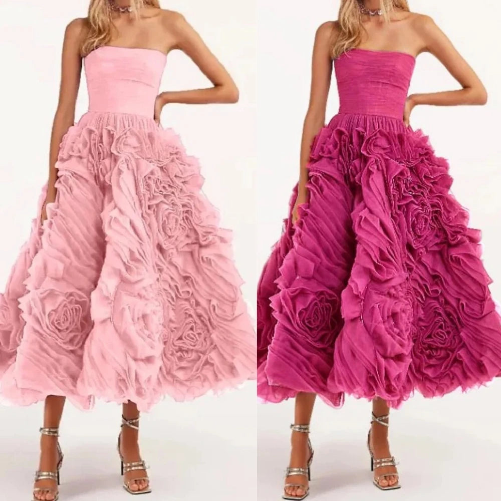 Two strapless dresses with floral details, one pink and one magenta, on a white background.