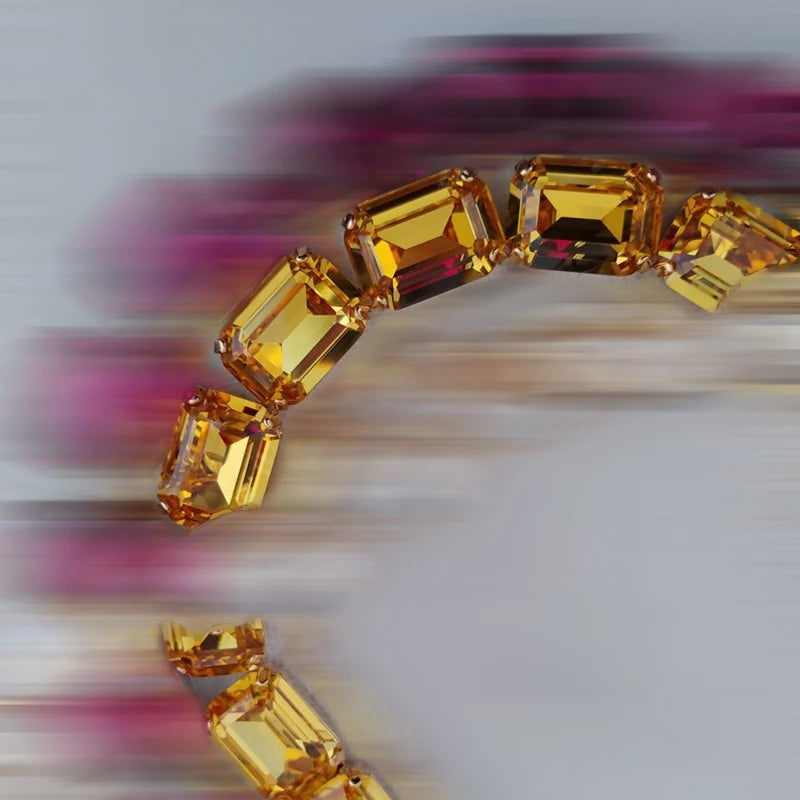 Gold bracelet with large gemstones on a blurred background