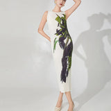 Woman wearing a sleeveless dress with abstract green and black design on a white background
