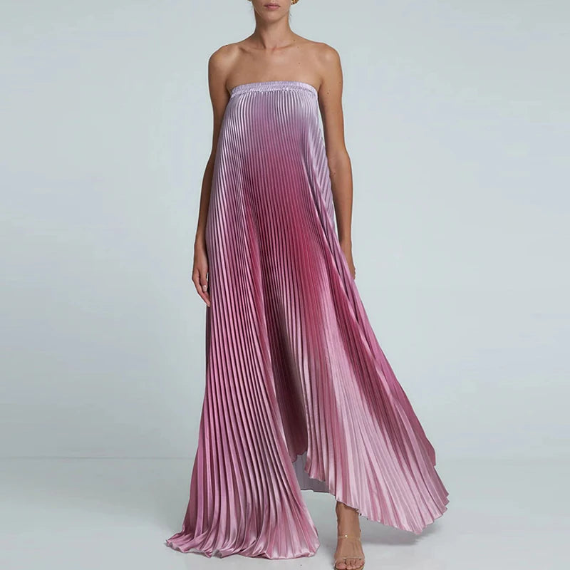 Woman wearing a strapless pleated dress with a gradient of pink and purple on a light gray background