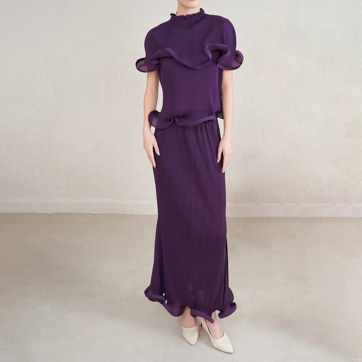 Purple outfit with ruffled top and long skirt on a neutral background