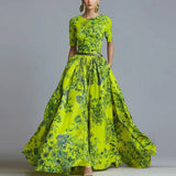 Woman wearing a bright green floral dress against a gray background