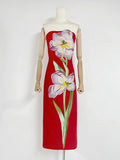 Red dress with floral design on a mannequin against a white background