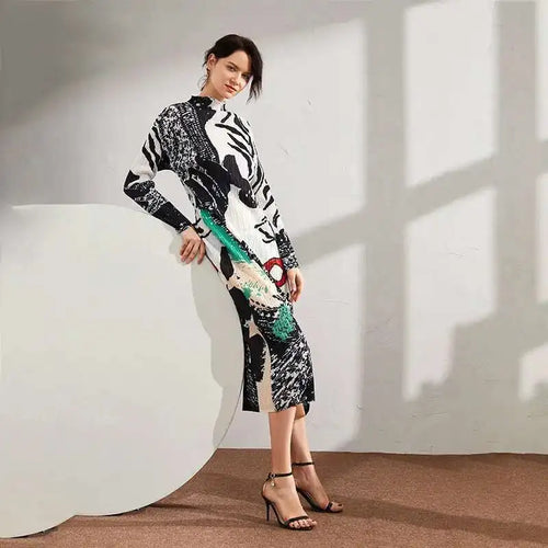 Woman wearing a patterned dress standing against a white wall with a large circular object.
