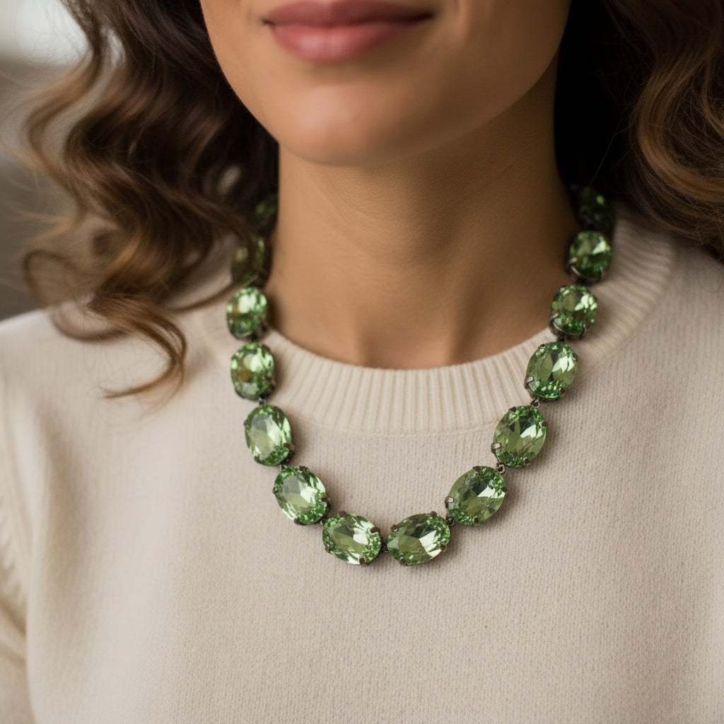 A vintage-style green rhinestone collar necklace displayed on a white mannequin bust with a dark red neck collar.