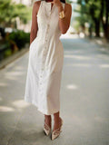 Woman wearing a white sleeveless dress with buttons in a neutral setting