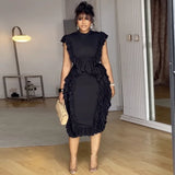 Woman wearing a black ruffled dress in an indoor setting
