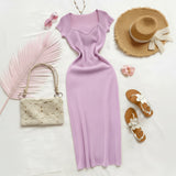 Purple dress with accessories including a straw hat, sandals, and handbag on a white background