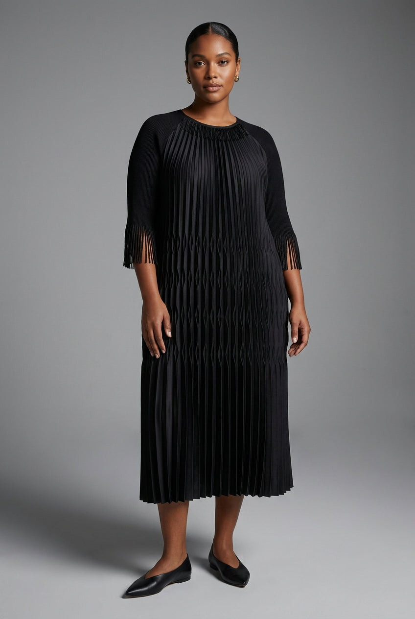 A black pleated midi dress with short sleeves and a round neckline, displayed on a hanger against a textured beige wall.