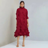 Woman wearing a red dress with ruffled layers on a plain background