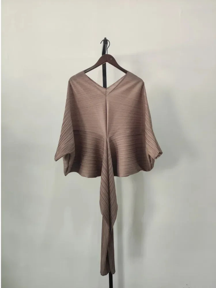 Brown poncho on a hanger against a plain background