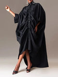Black dress with a draped design worn by a model on a plain background