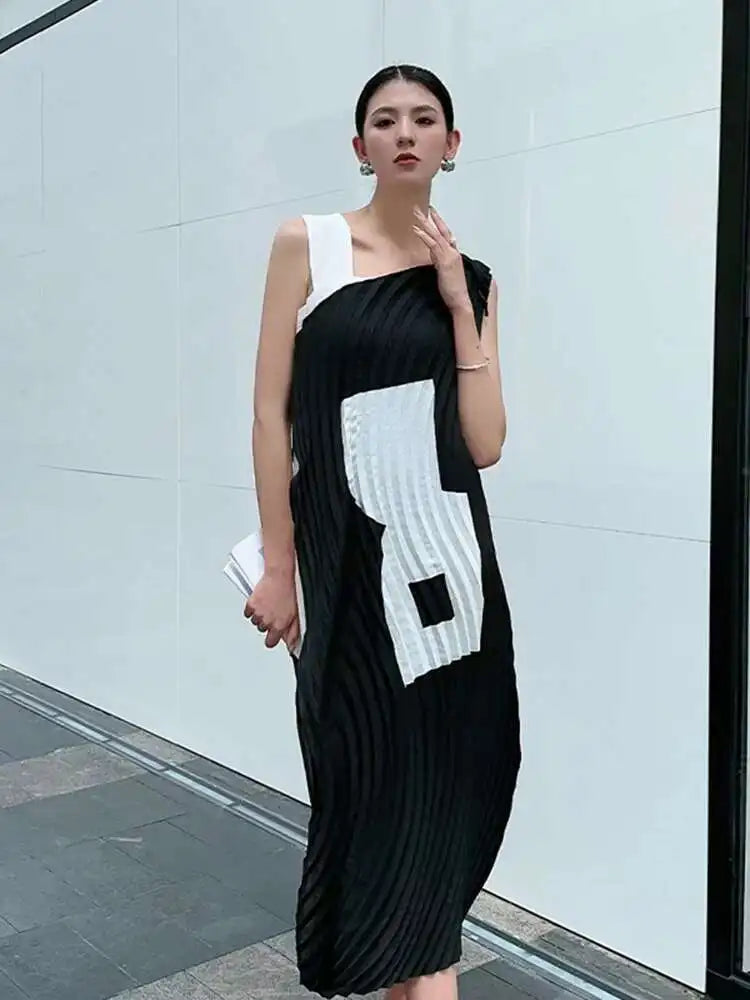 Woman wearing a black and white dress with geometric patterns in an urban setting.
