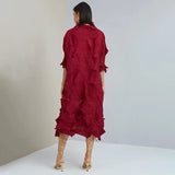 Woman wearing a red dress with ruffled layers on a plain background