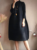 Person wearing a black dress with a plain background