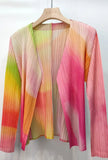 Colorful pleated garment on a hanger against a white background