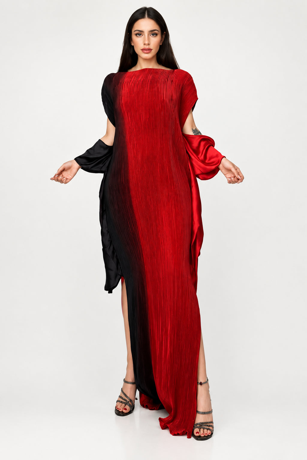 A woman models a long, pleated maxi dress with a red-to-black gradient and cold-shoulder sleeves. The brand name 'winyi' is visible in the top left corner against a gray studio background.
