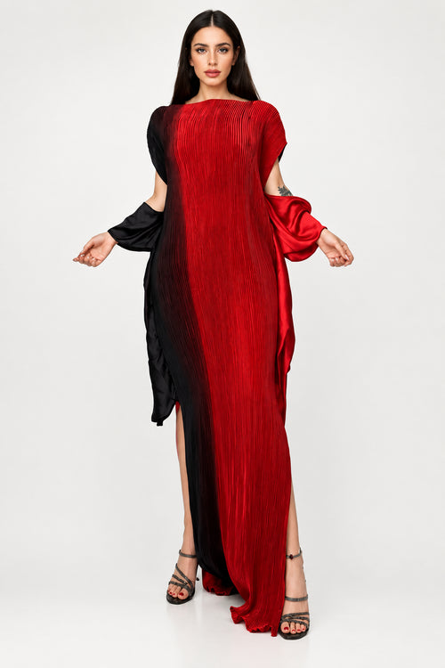 A woman models a long, pleated maxi dress with a red-to-black gradient and cold-shoulder sleeves. The brand name 'winyi' is visible in the top left corner against a gray studio background.