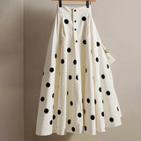White skirt with black polka dots on a hanger against a beige background, featuring the brand 'JoinYouth'.