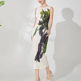 Woman wearing a sleeveless dress with green and black abstract pattern on a white background