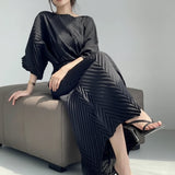 Person wearing a black outfit sitting on a gray couch.