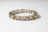Gold bracelet with clear stones on a blurred background