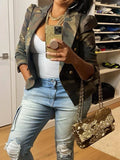 Person wearing a camouflage jacket, white top, and light blue jeans, holding a gold glittery handbag.