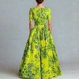 Woman wearing a bright green floral dress against a plain background