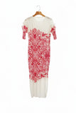 White dress with red floral pattern on a hanger against a background of shelves with shoes and socks.